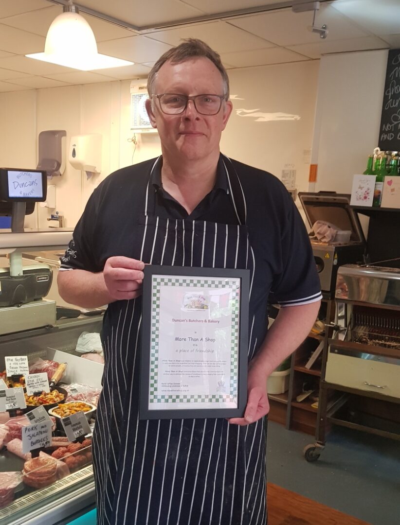 Duncan of Duncan's Butchers, holding their More Than A Shop certificate