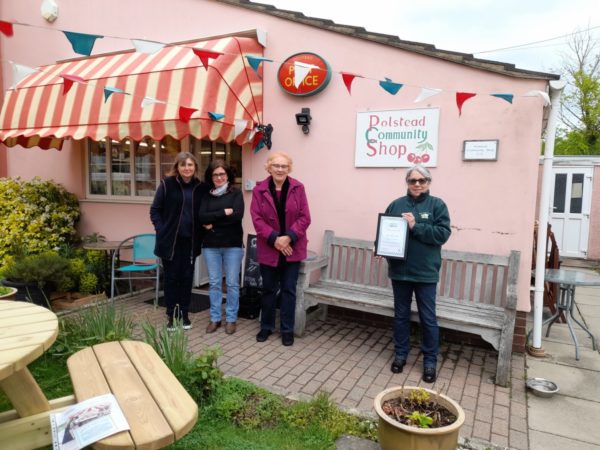 RCC Volunteer Norma presenting Polstead Community Shop with their More Than A Shop Award Polsted Community Shop More Than A Shop Presentation Photo