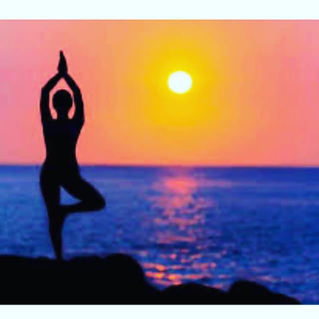 Stardust Yoga Facebook image of silhouetted figue in yoga pose in front of sunset by the sea
