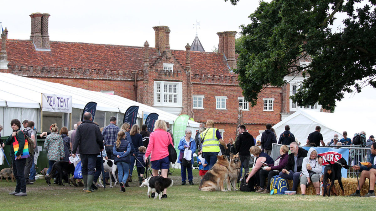 Suffolk Dog Day press photo of a crowd of people and their dogs with Helmingham Hall in the background