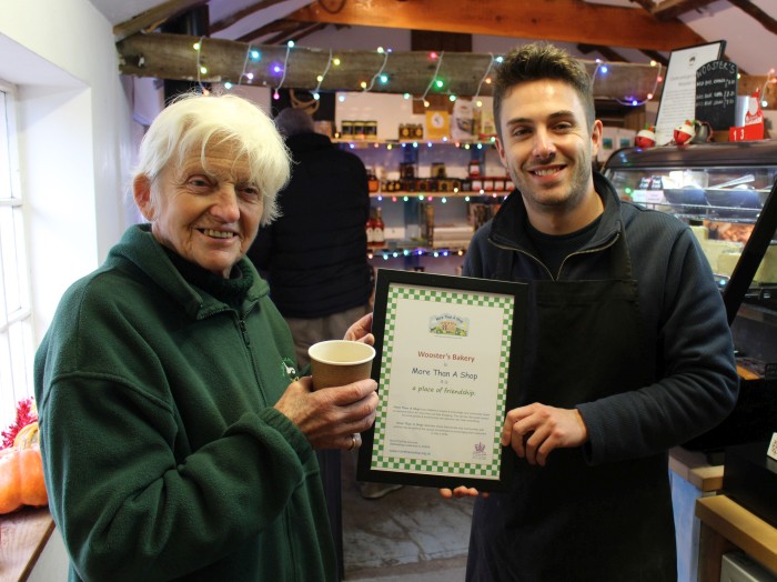 Woosters Deli being presented with their More Than A Shop certificate by Canon Sally Fogden of Rural Coffee Caravan