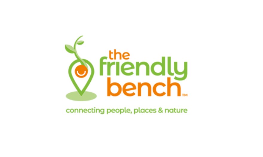 The friendly bench logo with green and orange text on white background alongside graphic of seedling growing out of digital map place tag icon